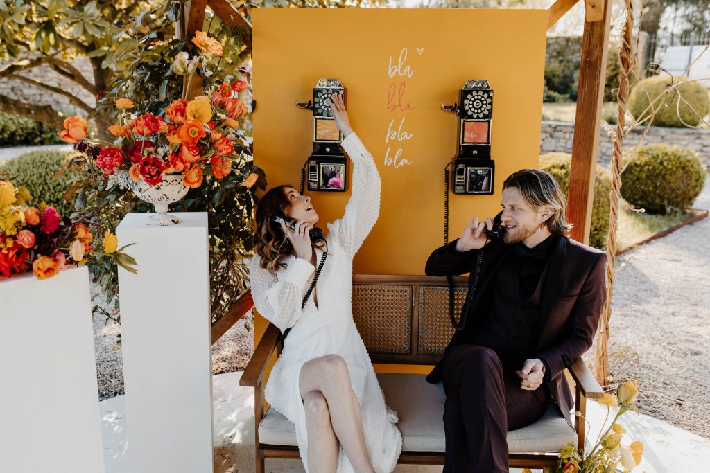 Mariés décrochent les combinés et écoutent les messages sur les livres d'or audio accrochés sur un panneau en bois